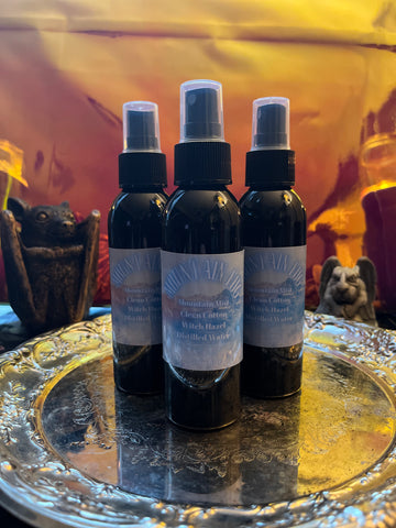 3 black bottles of Mountain fog Room Mist on a silver tray with a pink reflective background
