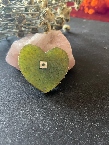 heart car air freshener on a table with some flowers and crystals