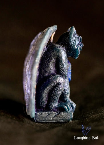 side view of indigo shimmering beeswax gargoyle with lapis lazuli crystal