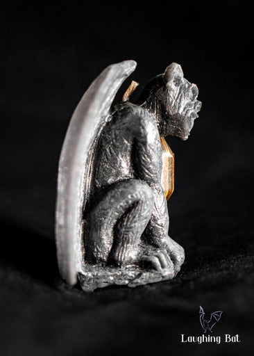 Side view of Black shimmering beeswax gargoyle with tigers eye double terminated crystal
